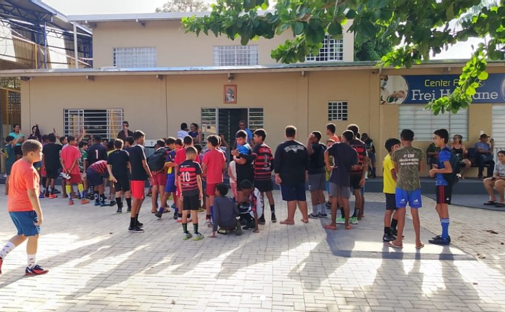 Crianças e adolescentes distribuídos pelo pátio durante a partida.